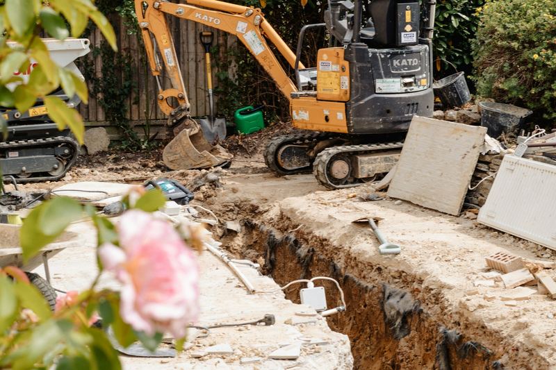 Mini excavator digging a trench in a backyard